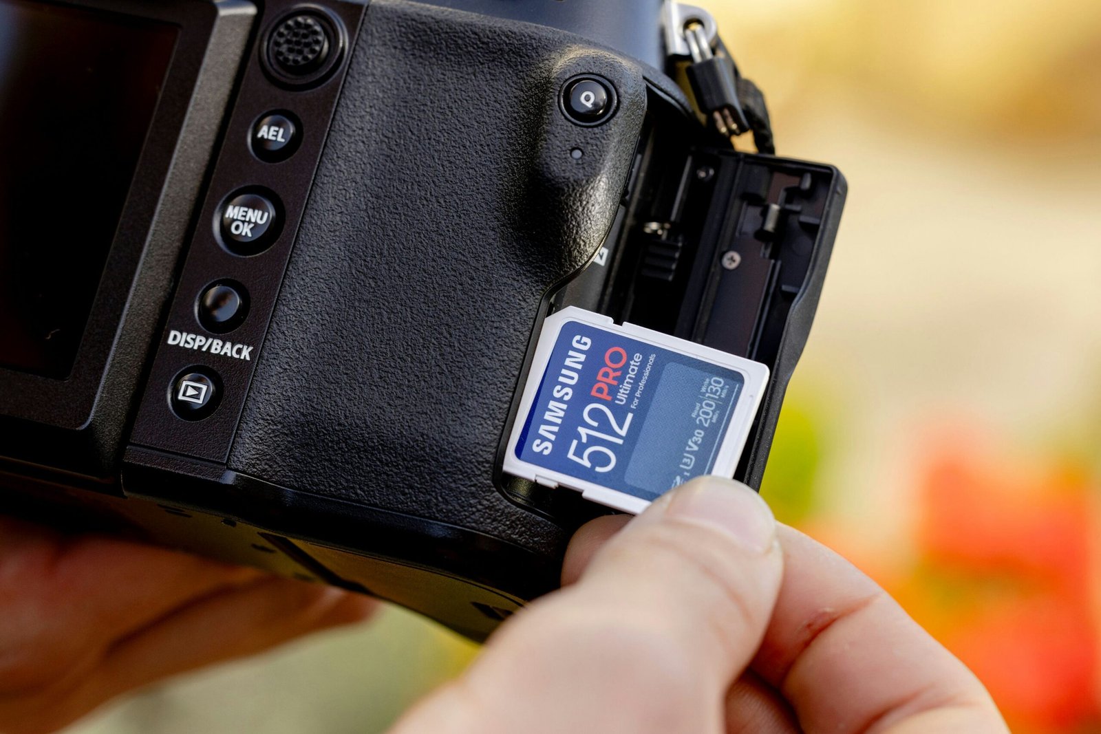 A person holding a camera with a memory card attached to it