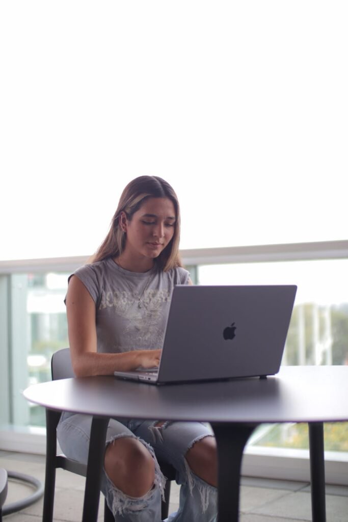 a woman sitting at a table with a laptop